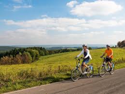 Een man en een vrouw fietsen over een weg.