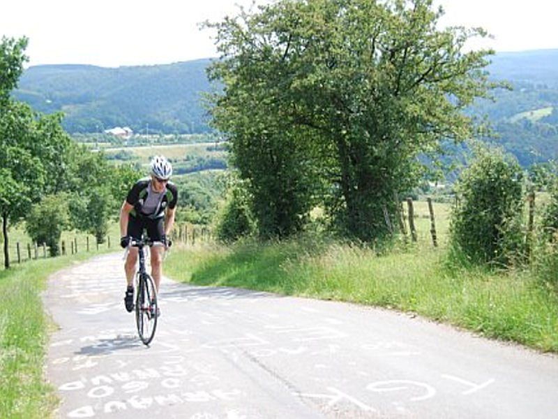 Een man fietst over een landweg.