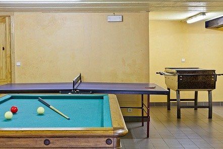Er is een pooltafel en een pingpongtafel in de kamer.
