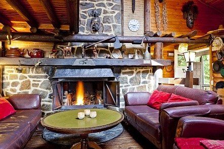 Een woonkamer met open haard en een bank