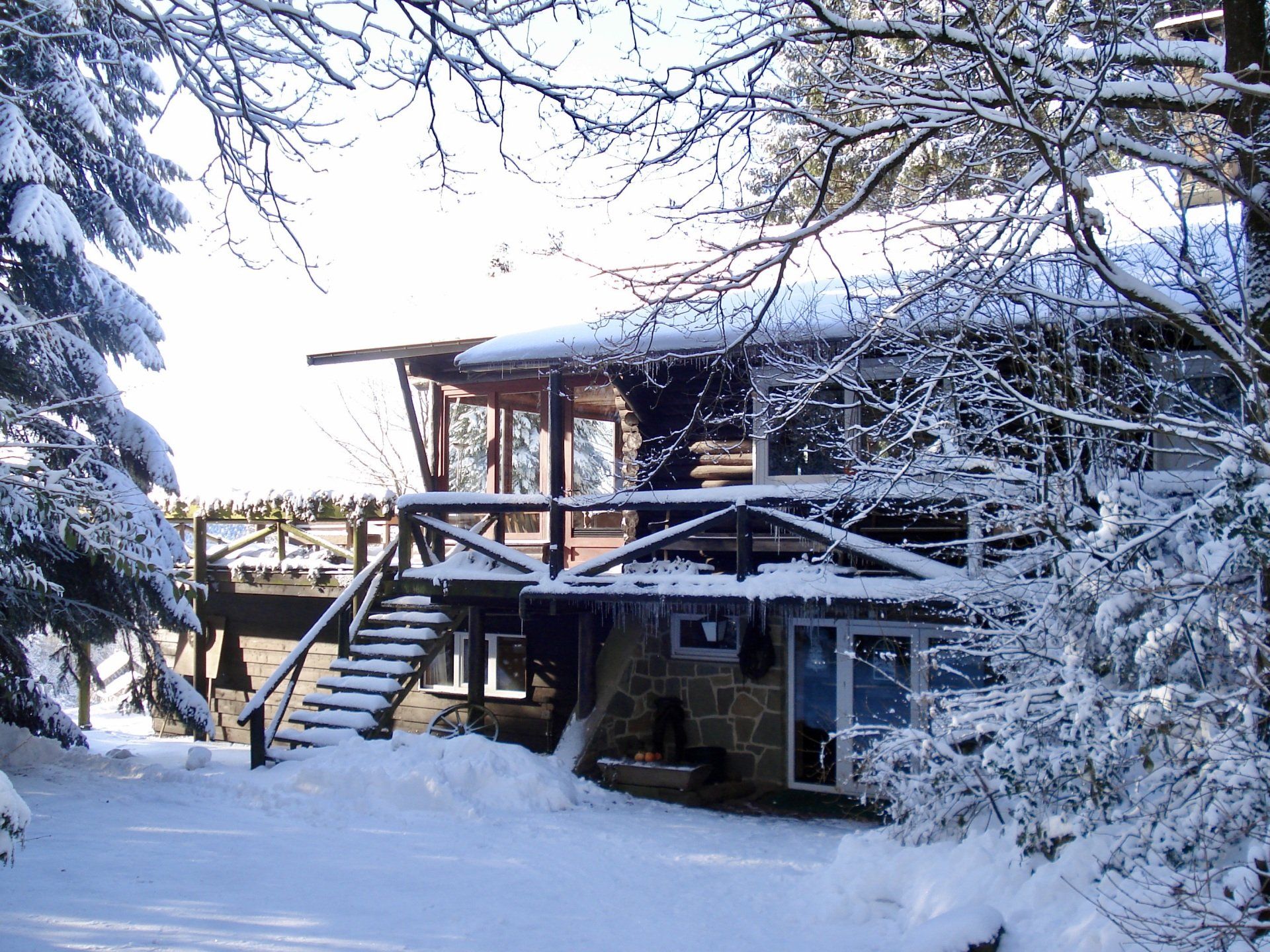 Een besneeuwd huis met een trap die ernaartoe leidt