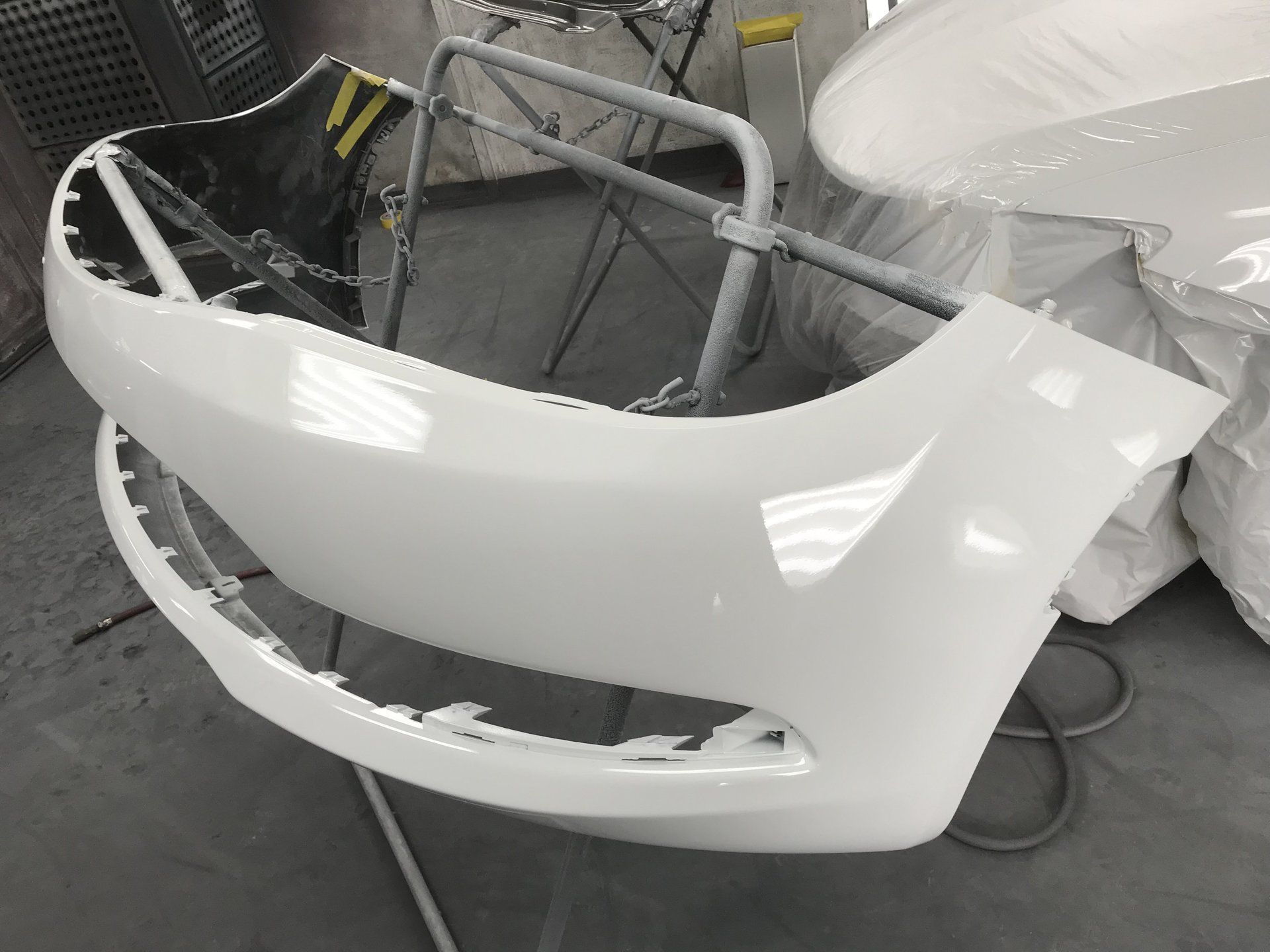 White car bumper in a paint booth.