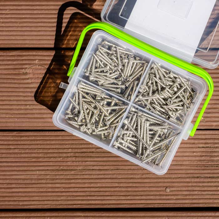 A box of screws is sitting on a wooden table.