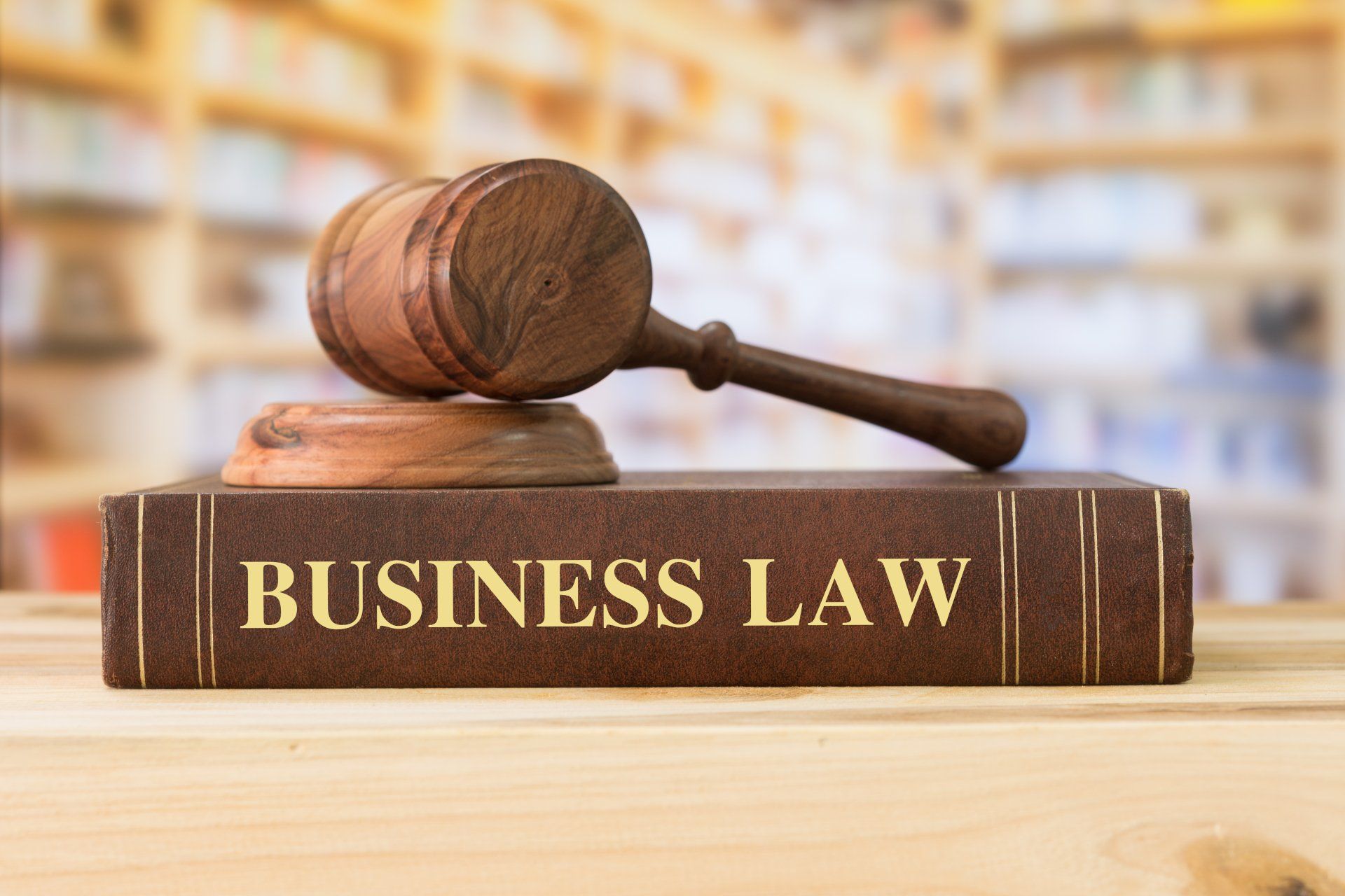 a wooden gavel is sitting on top of a book titled business law .