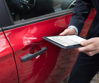 Car Wreck — Man Checking Car Insurance Online Using Tablet in Riverside, CA
