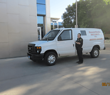 Security guard standing by van - security services in Bismarck, ND Security guard standing by van - security services in Bismarck, ND