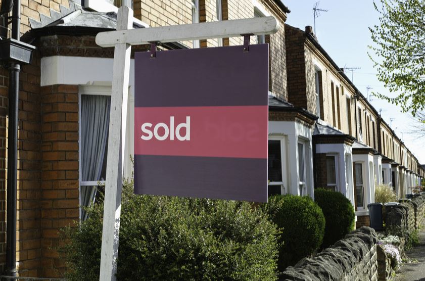 House with sold sign outside