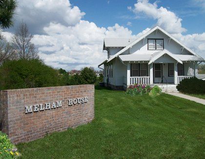 a white house with a sign that says Melham House