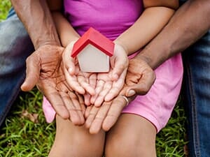 Hands of family together holding house - Housing in Rockland, MA Hands of family together holding house - Housing in Rockland, MA