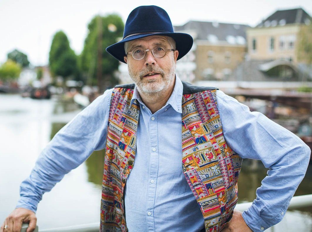 Peter Meijer. Een man met hoed en vest staat bij het water en kijkt in de camera.