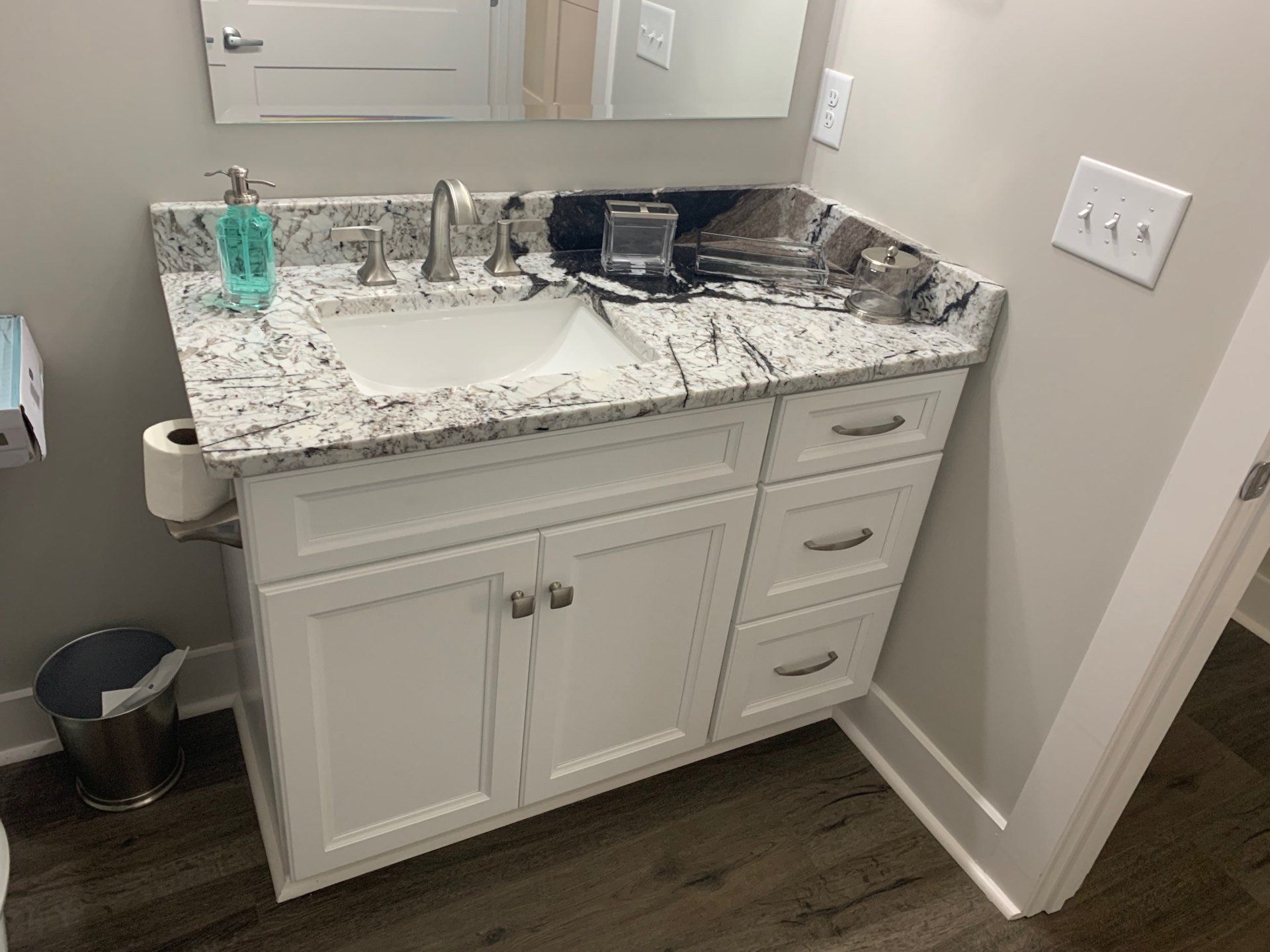 A bathroom vanity with a sink and a mirror.