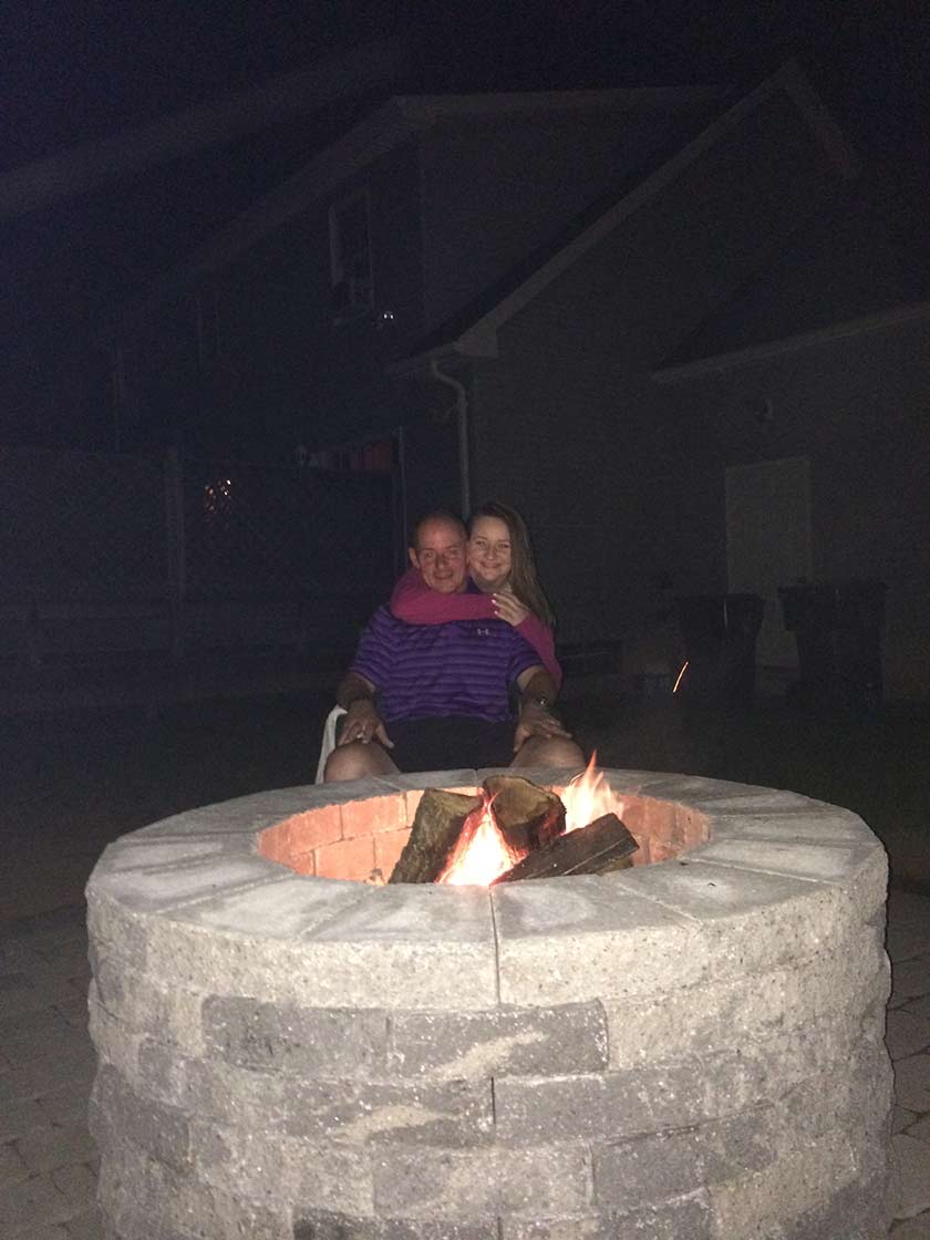 Couple In Front of Outdoor Fireplace – West Springfield, MA – Rolandini Brothers Masonry