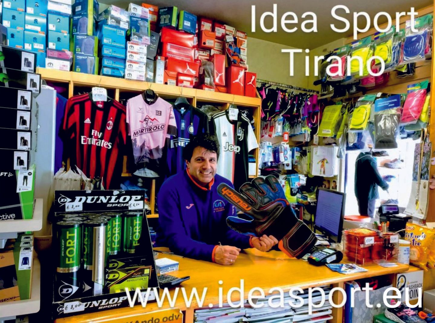 A man is sitting at a counter in a store called idea sport