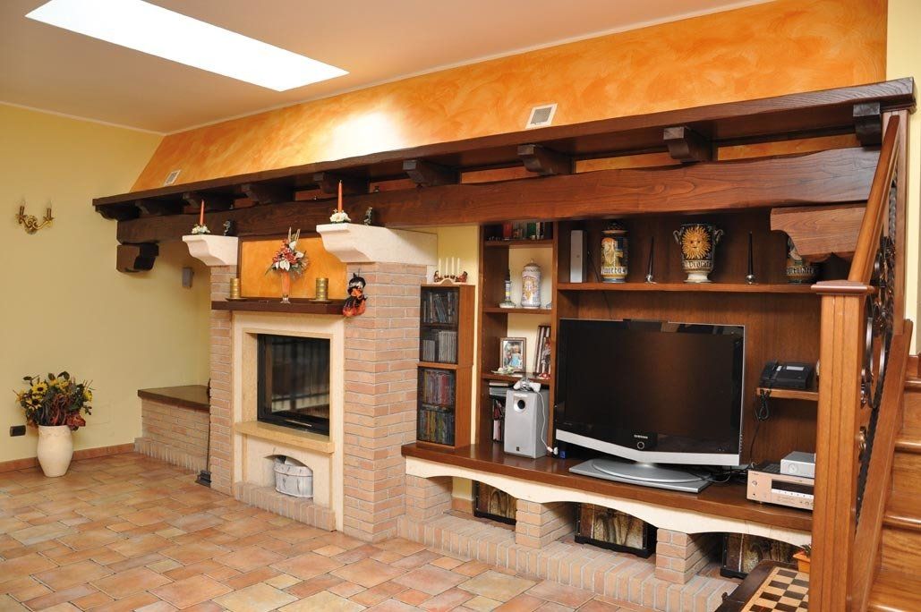 Soggiorno con camino in mattoni, centro di intrattenimento integrato e travi in legno.