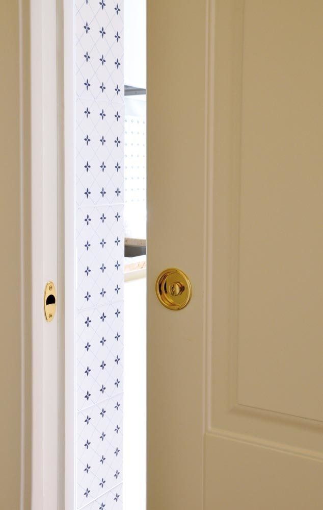 Porta beige parzialmente aperta con ferramenta dorata. Pellicola decorativa satinata visibile.