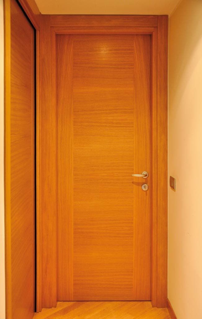 Porta interna in legno in un corridoio dai colori neutri.