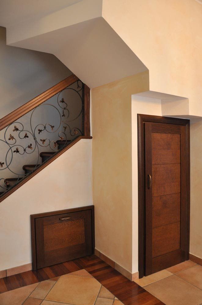Scala e porta in legno con cassetto incorporato sotto la scala.