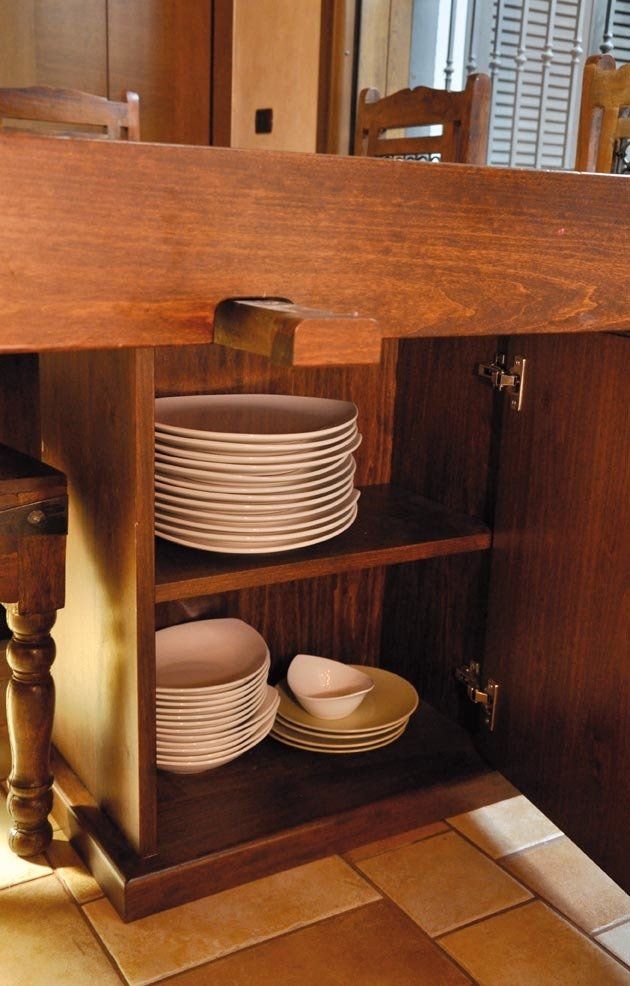 Mobiletto in legno con ante aperte, contenente pile di piatti.