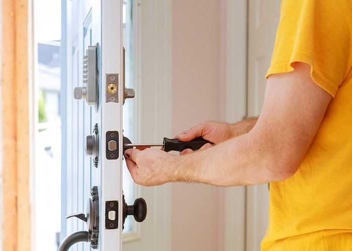 Door Replacement — Worker Installing Lock In Pompano Beach, FL