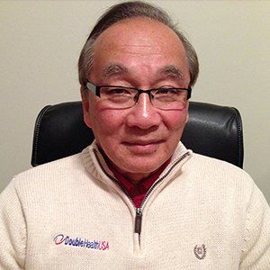 A person with glasses wears a cream-colored zip-up sweater featuring a 