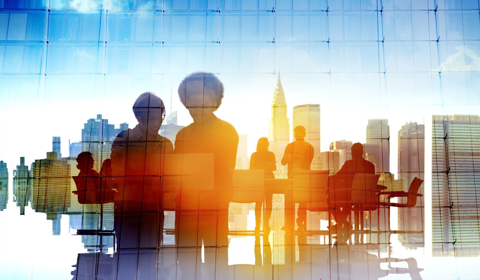 Silhouettes of people in a meeting room, overlaid with a bright cityscape in golden hues.