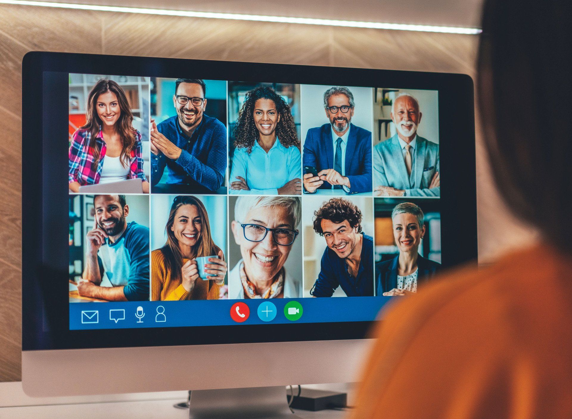 A computer screen displays a video conference with eight diverse participants in a grid layout.