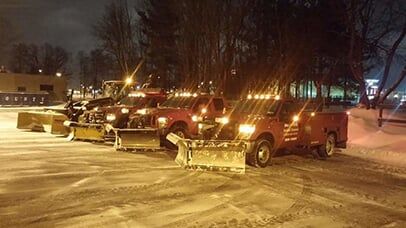 Red trucks with snowplows.