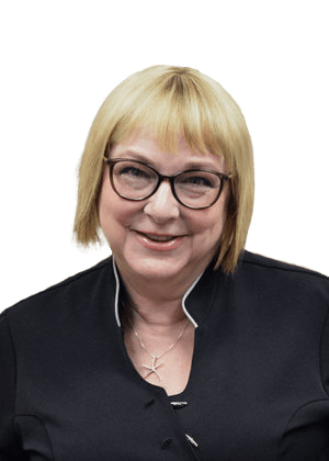 Smiling woman with blonde bob, glasses, and black top against a white background