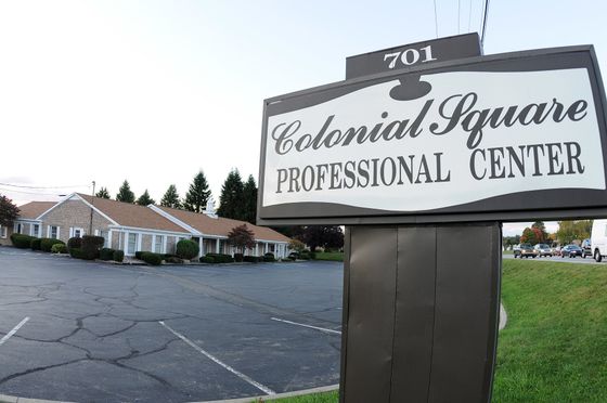 Colonial Square Professional Center sign outside a low, white office building and parking lot