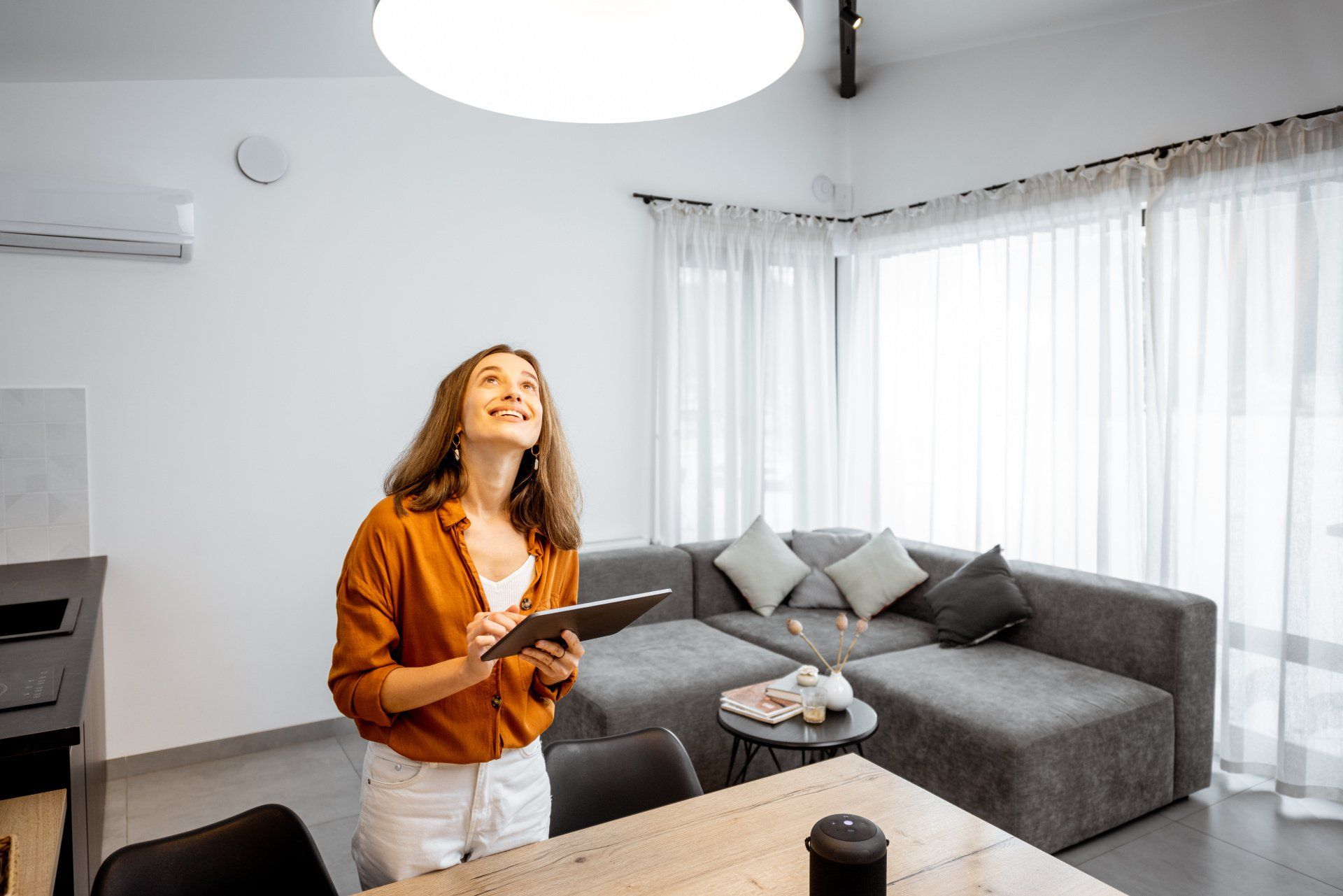 Lady using tablet to control light in ceiling