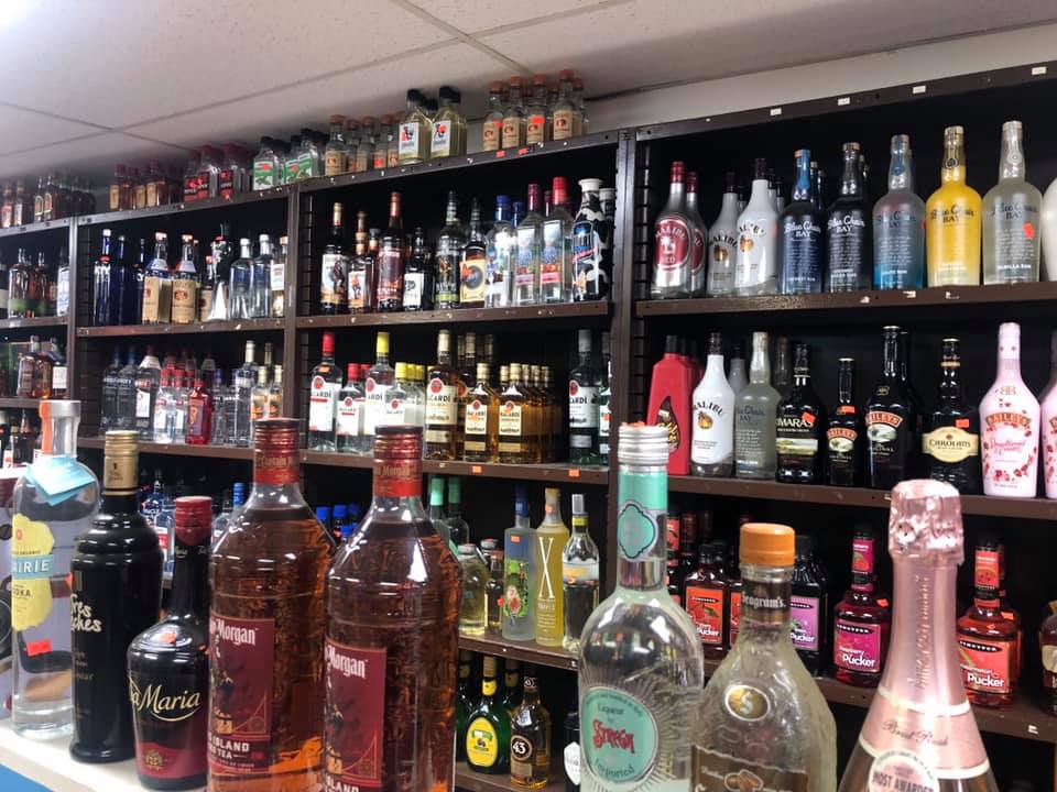Bottles of liquor are lined up on shelves in a store