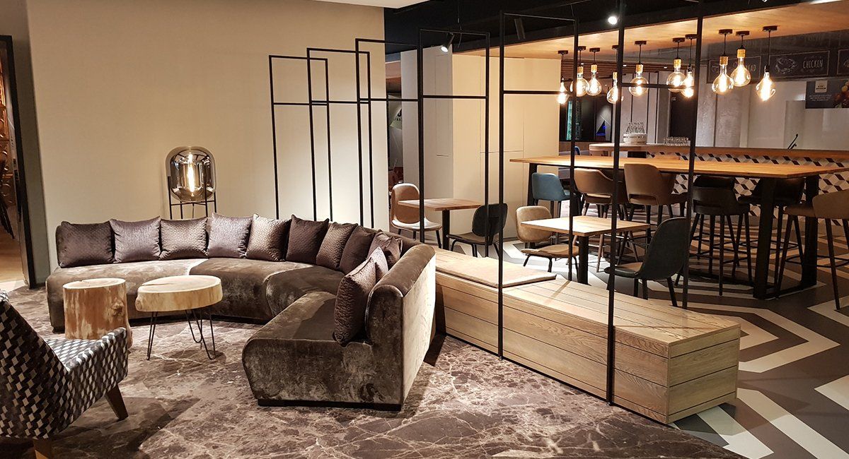 Satelliet showroom with a sectional sofa and two armchairs. Decorative lighting and marble flooring.