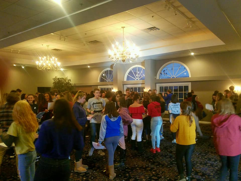 A large group of people are dancing in a large room.