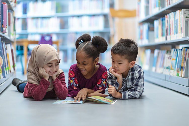 Three Children reading a book together - Dental Studio 4 Kids Lutz Florida