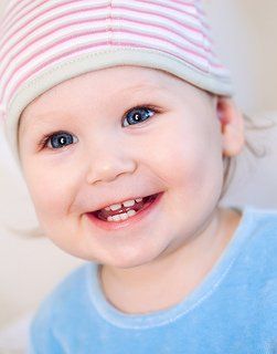 baby girl in blue shirt smiling