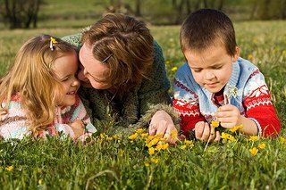 kids and mom laying on grass