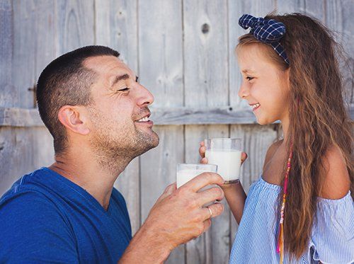 father and daughter drinking milk