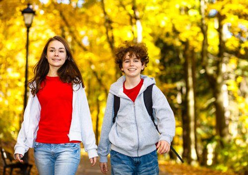 boy and girl walking through the woods