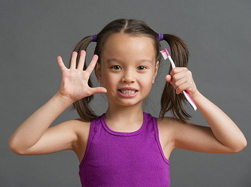 girl holding toothbrush