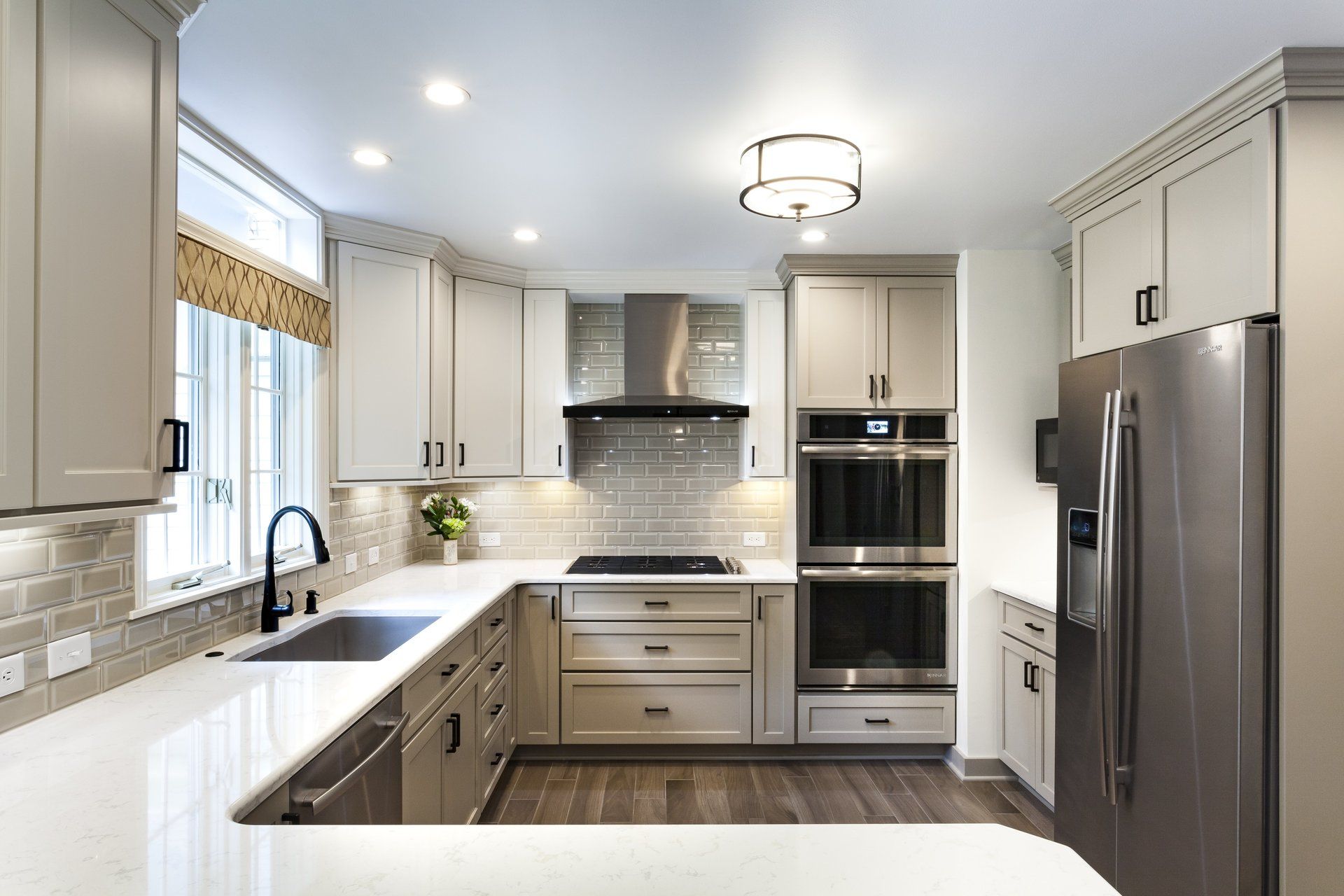 Bright modern kitchen with white cabinets, stainless steel appliances, and a large island countertop