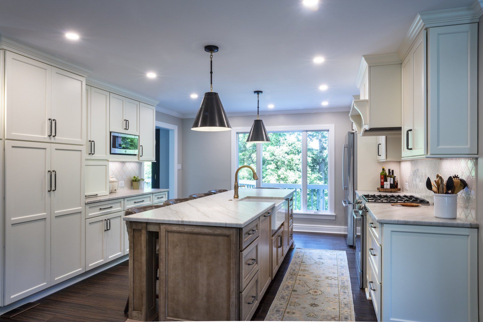 Bright modern kitchen with white cabinets, center island, and large window