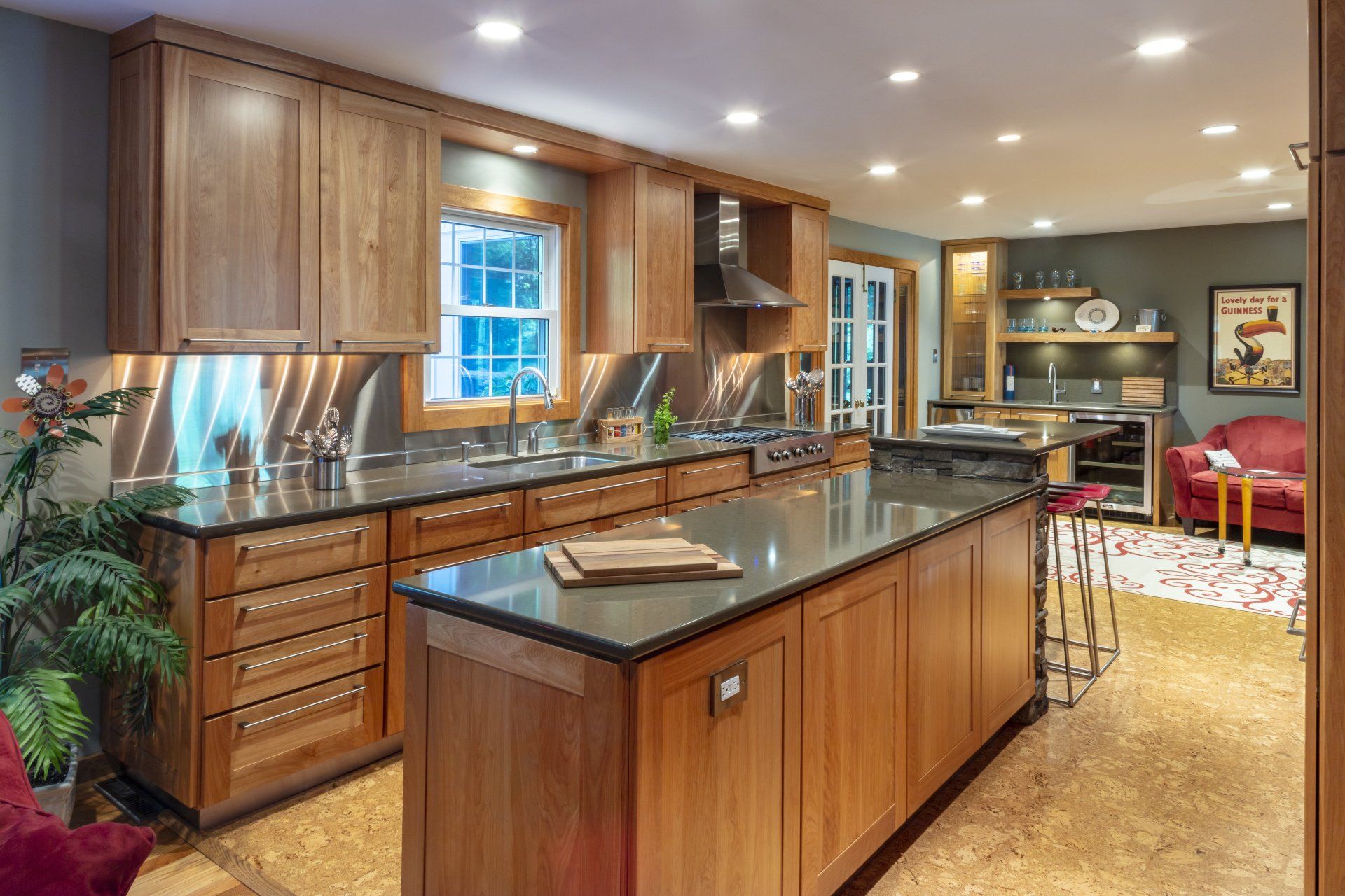 Spacious modern kitchen with wood cabinets, granite island, and warm recessed lighting