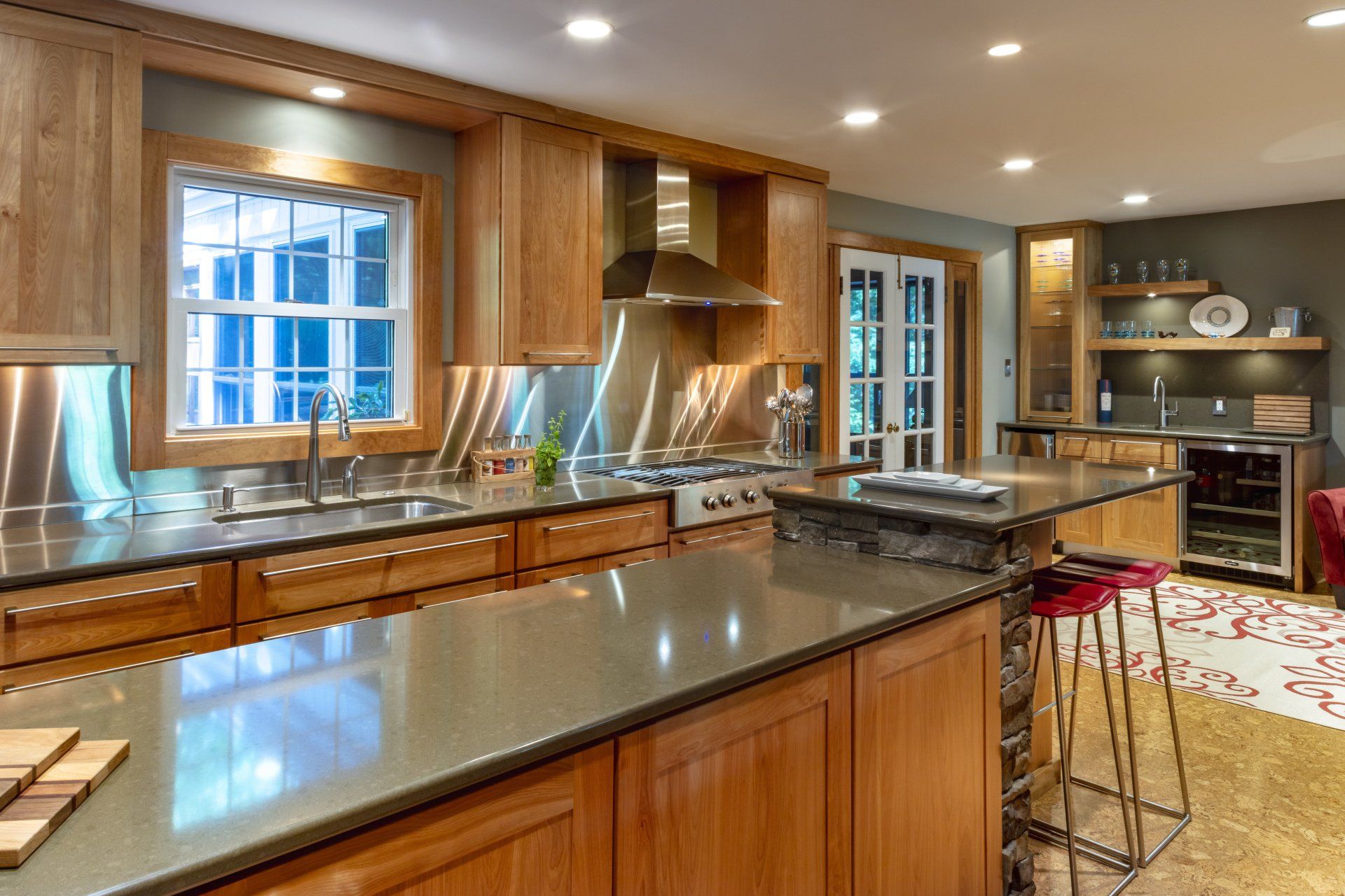 Modern kitchen with wood cabinets, granite island, stainless-steel appliances, and a window over the sink