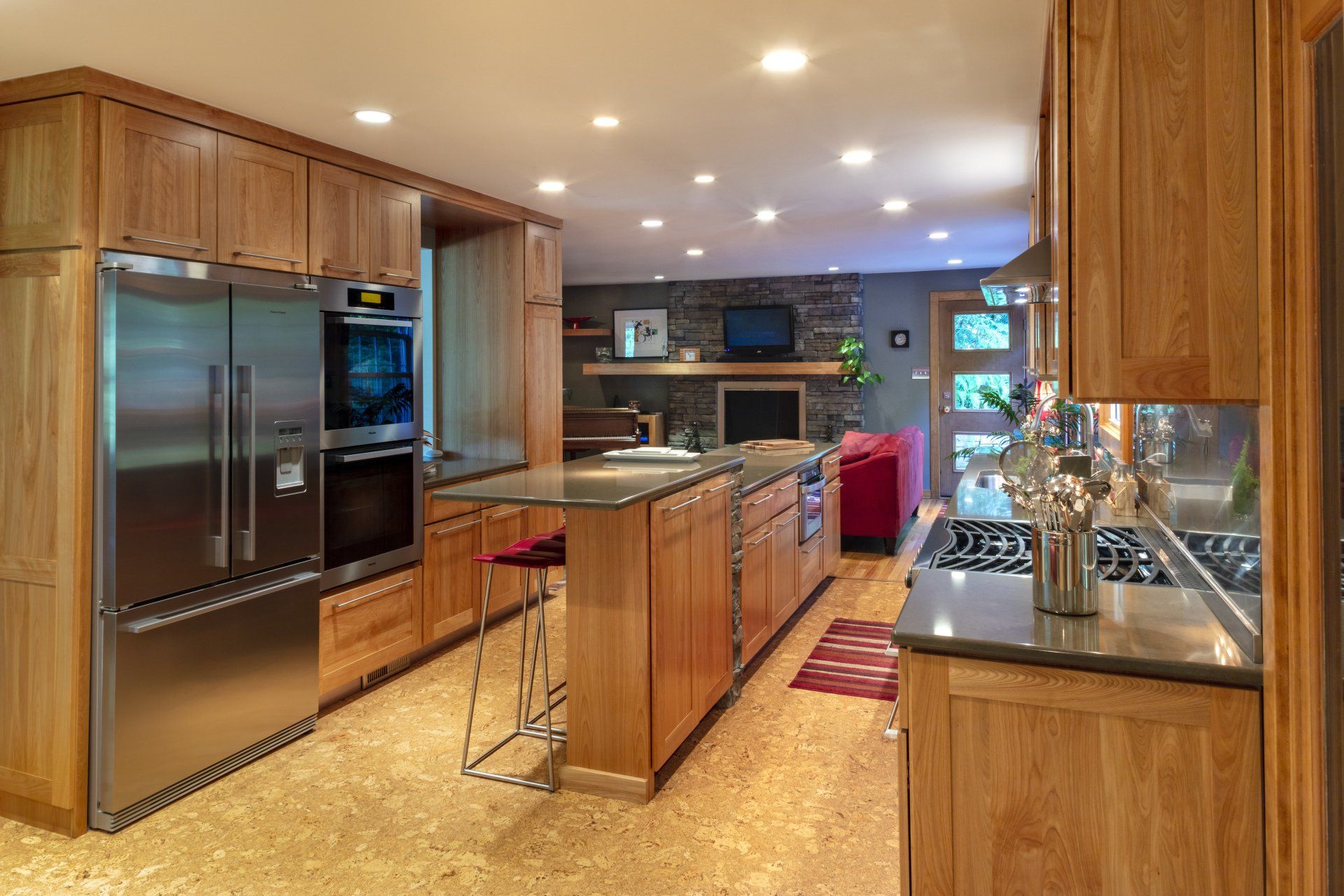 Modern kitchen with wood cabinets, stainless steel appliances, island seating, and recessed lighting