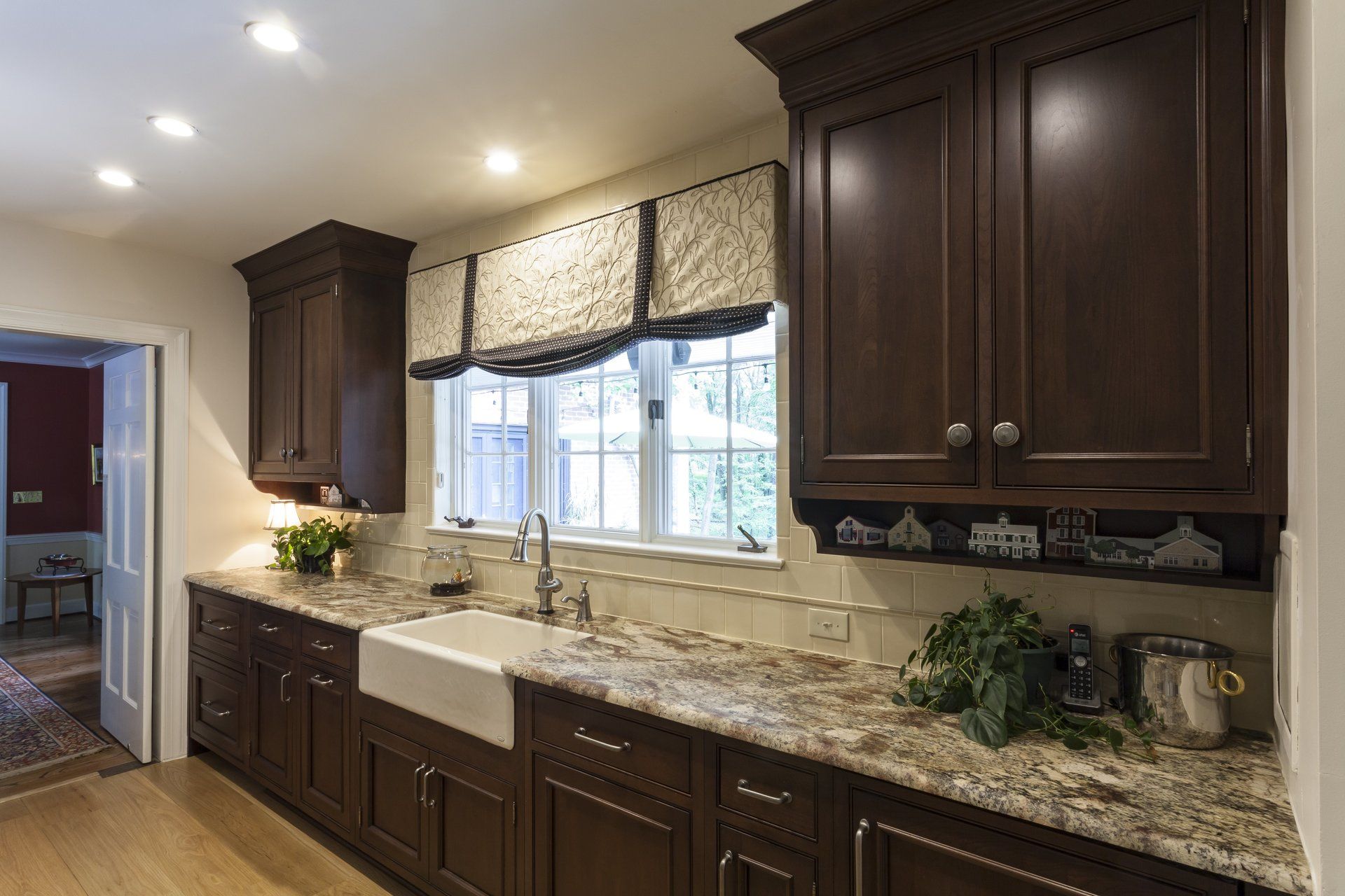 Kitchen with dark wood cabinets, granite countertops, and a window over the sink.