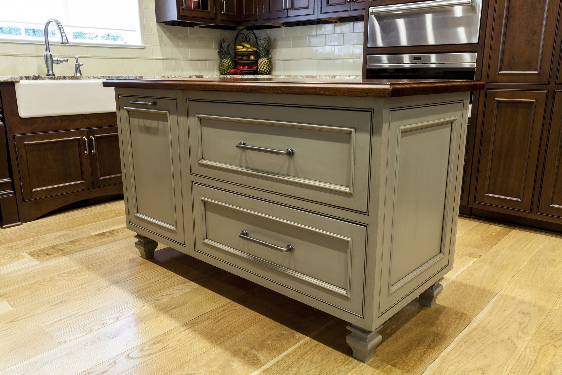 Cream kitchen island with drawers and chrome handles in a bright modern kitchen