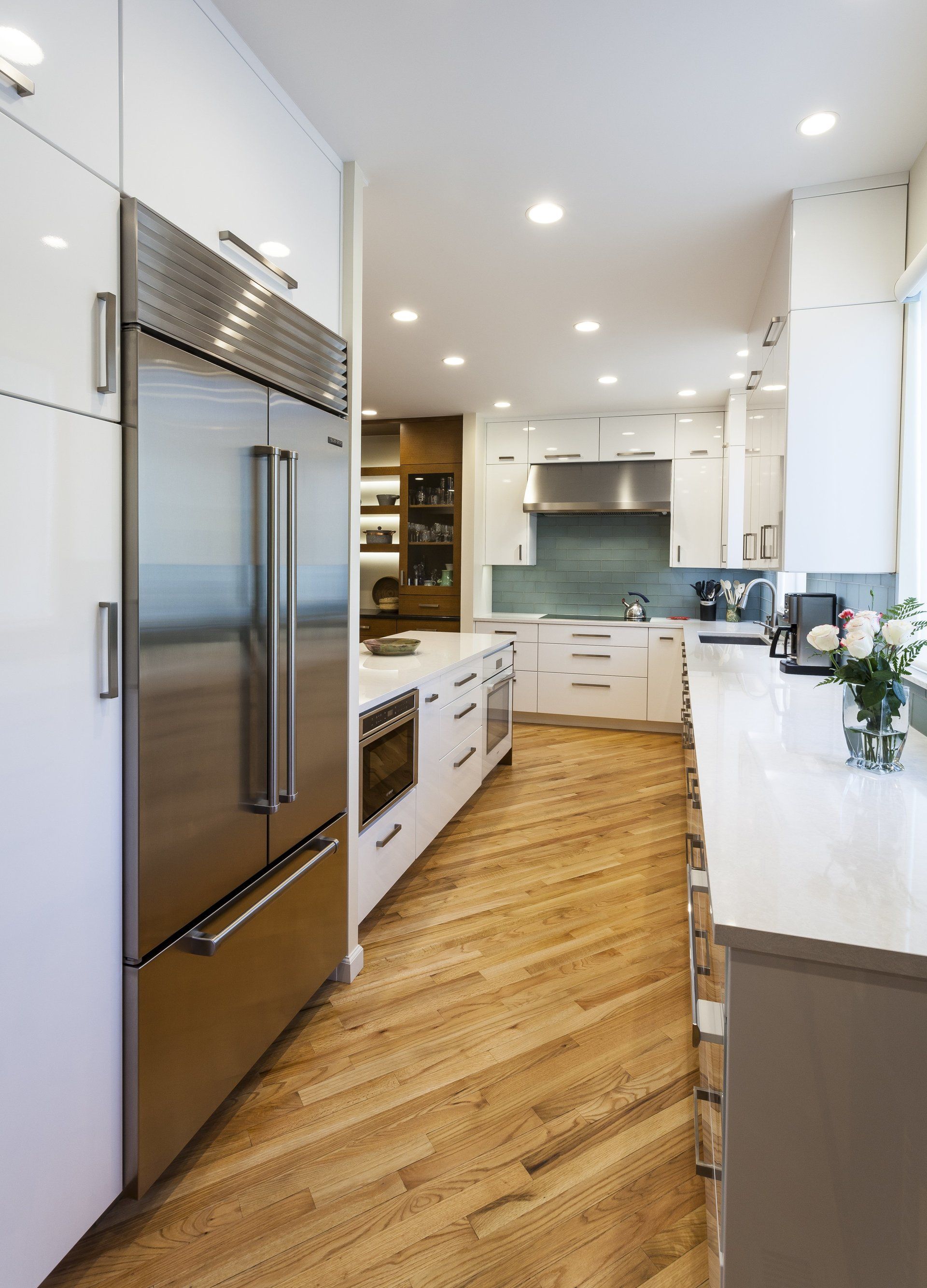 A kitchen with stainless steel appliances and wooden floors