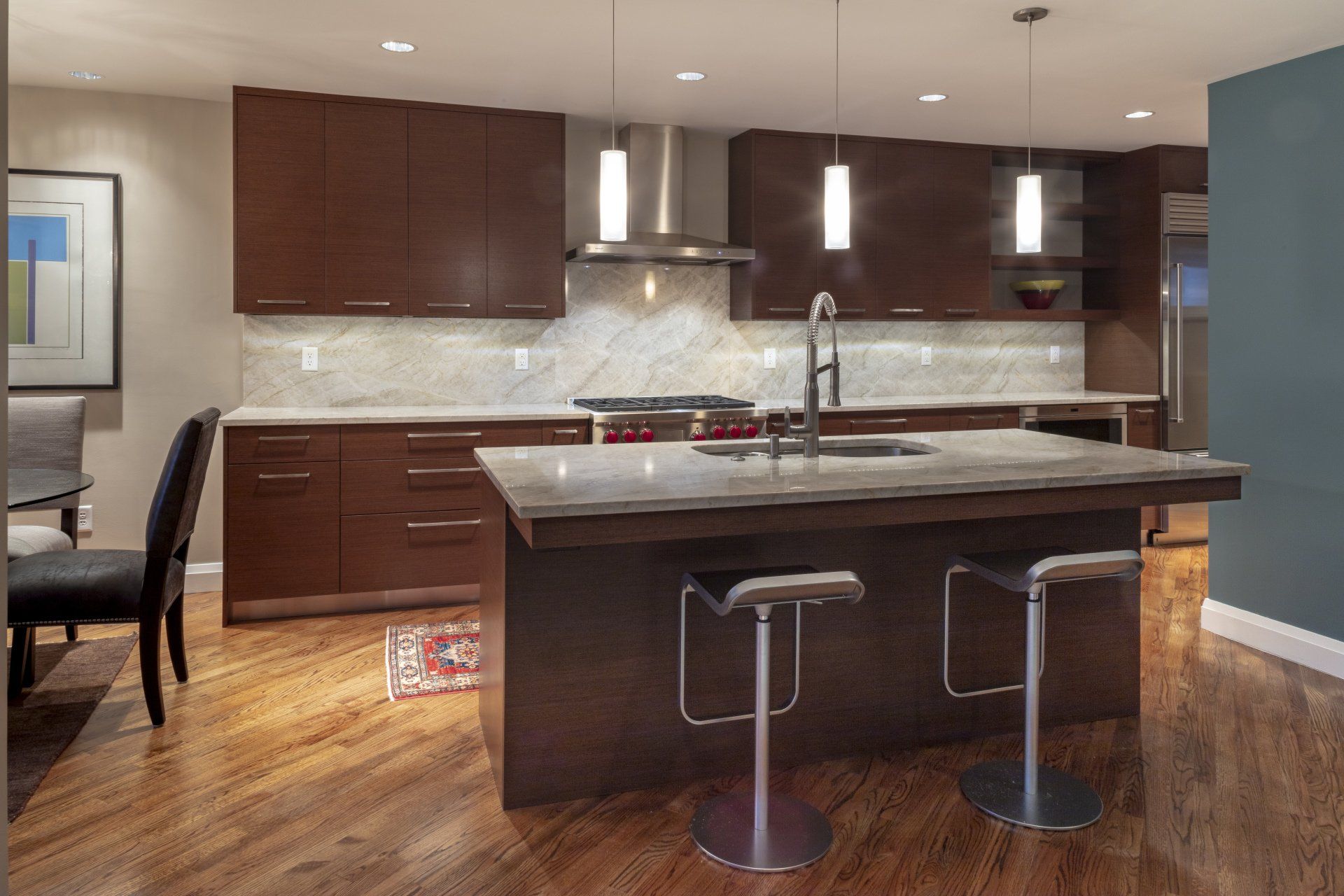 Modern kitchen with dark wood cabinets, stainless appliances, and a central island with stools