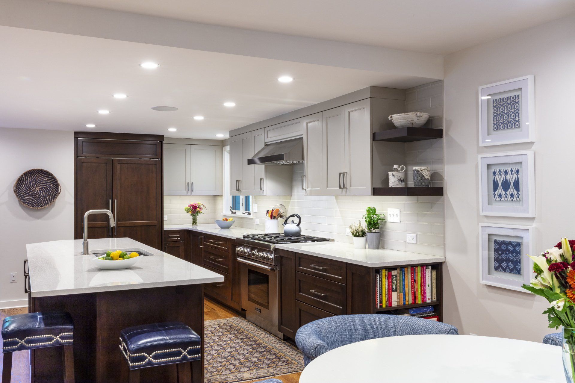 Modern kitchen with gray cabinets, white island, dark wood accents, and recessed lighting