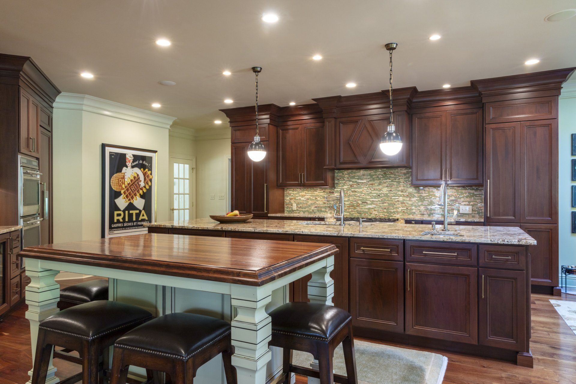 Modern kitchen with dark wood cabinets, island seating, pendant lights, and tiled backsplash